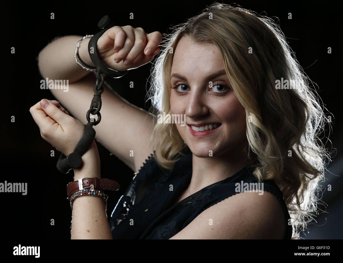 Evanna Lynch, who played Luna Lovegood in the Harry Potter films, and who is currently touring in a new play about the life of Harry Houdini, playing his wife, models a pair of handcuffs at Leicester Square's Hippodrome which Houdini used in one of his most famous escape routines. Stock Photo