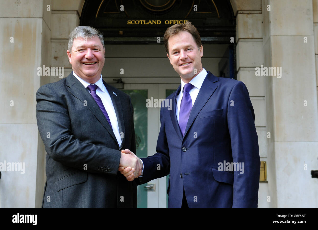 Orkney and Shetland MP Alistair Carmichael,(left) who has replaced Michael Moore as the Scottish Secretary, is greeted by Deputy Prime Minister and Liberal Democrat leader Nick Clegg, as he arrives at the Scotland Office, Whitehall, central London, after Prime Minister David Cameron, kicked off a coalition reshuffle, with Scottish Secretary Michael Moore among the casualties. Stock Photo