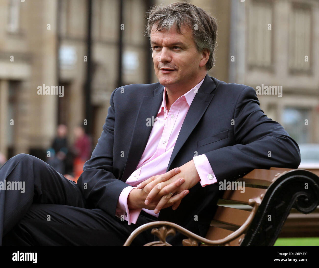 Liberal Democrat MP Michael Moore sits on a park bench close to his constituency office in Galashiels after a TV interview following him being replaced as Scottish Secretary by Orkney and Shetland MP Alistair Carmichael as part of a coalition reshuffle. Stock Photo