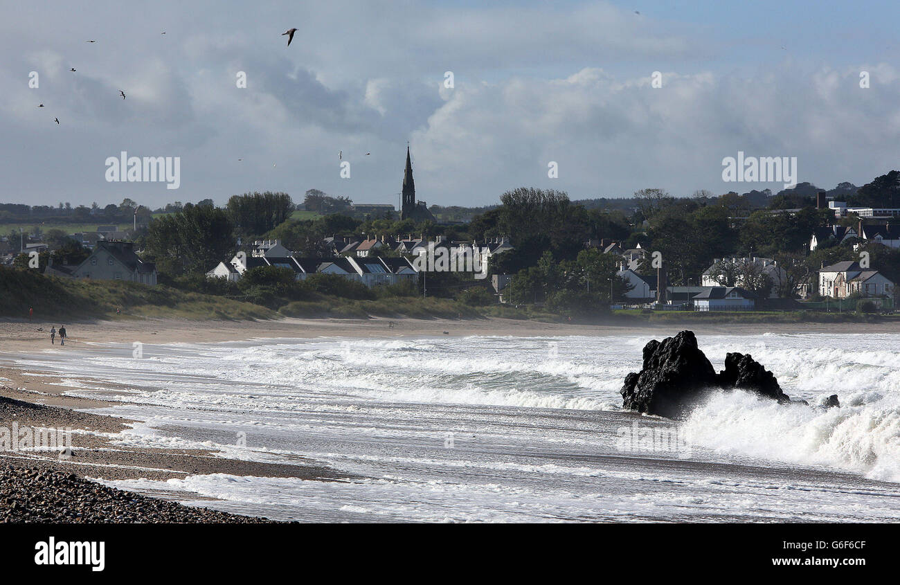 Two people walk along the beach at Ballycasle in Co Antrim, as strong winds force ferry crossings to nearby Rathlin island to be cancelled. Stock Photo