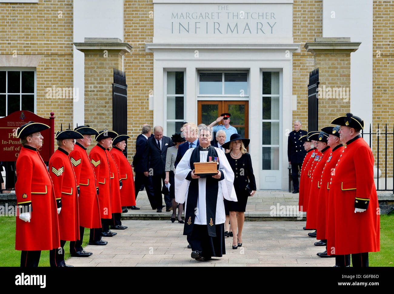 The Reverend Richard Whittington carries an oak casket with the ashes of former Prime Minister Baroness Margaret Thatcher, followed by (left to right) her daughter Carol, son Sir Mark and his wife Sarah, after leaving the chapel at the Royal Hospital Chelsea, to be laid to rest in the grounds. Stock Photo