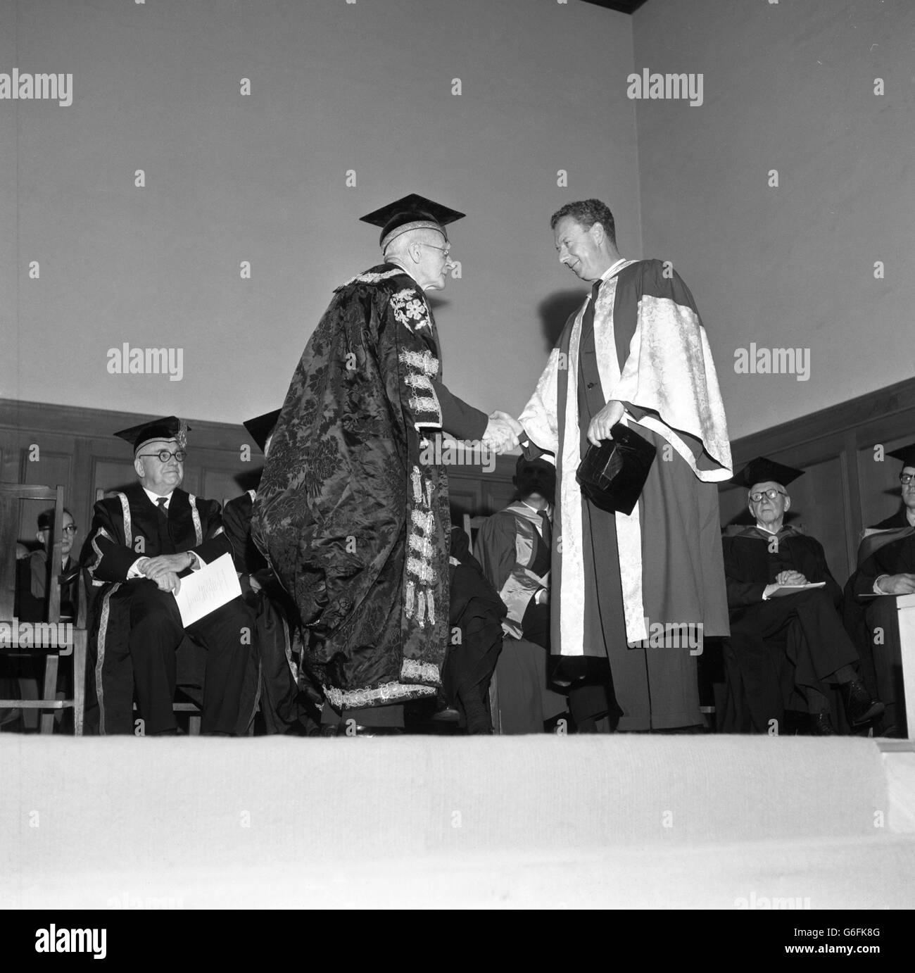 Chancellor Lord Adrian shakes hands with composer Benjamin Britten, who received an honorary Doctor of Music degree at the University of Leicester. Britten is the director of the English Opera Group and Artistic Director of the Aldeburgh Festival. Stock Photo