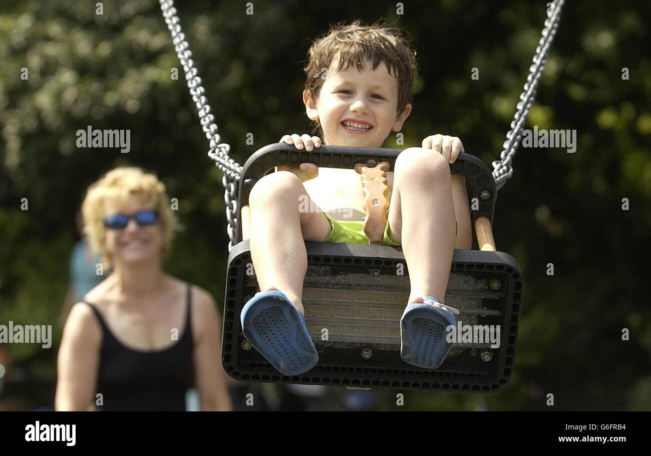 A child plays on the swings at Hyde Park Lido, central London. As temperatures soar and children seek outdoor activities, a report issued today by the Childrens Society says youngsters are having their development stifled by intolerant adults who are stopping them from playing outdoors. Most often youngsters are told off by parents and neighbours for making a 'noise' and being a 'nuisance' says the charity. Stock Photo