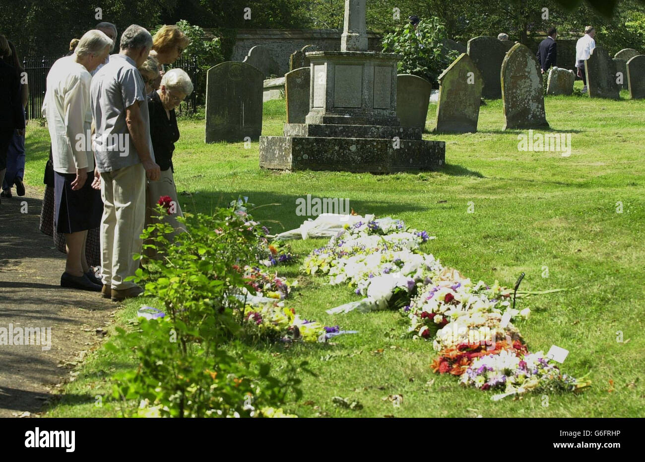 Mourners look at the floral tributes left for Dr David Kelly at St Mary's Church in Longworth, Oxfordshire. Around 160 mourners including Deputy Prime Minister John Prescott and Lord Hutton, who is leading the inquiry into Dr Kelly's apparent suicide, had arrived earlier. Stock Photo