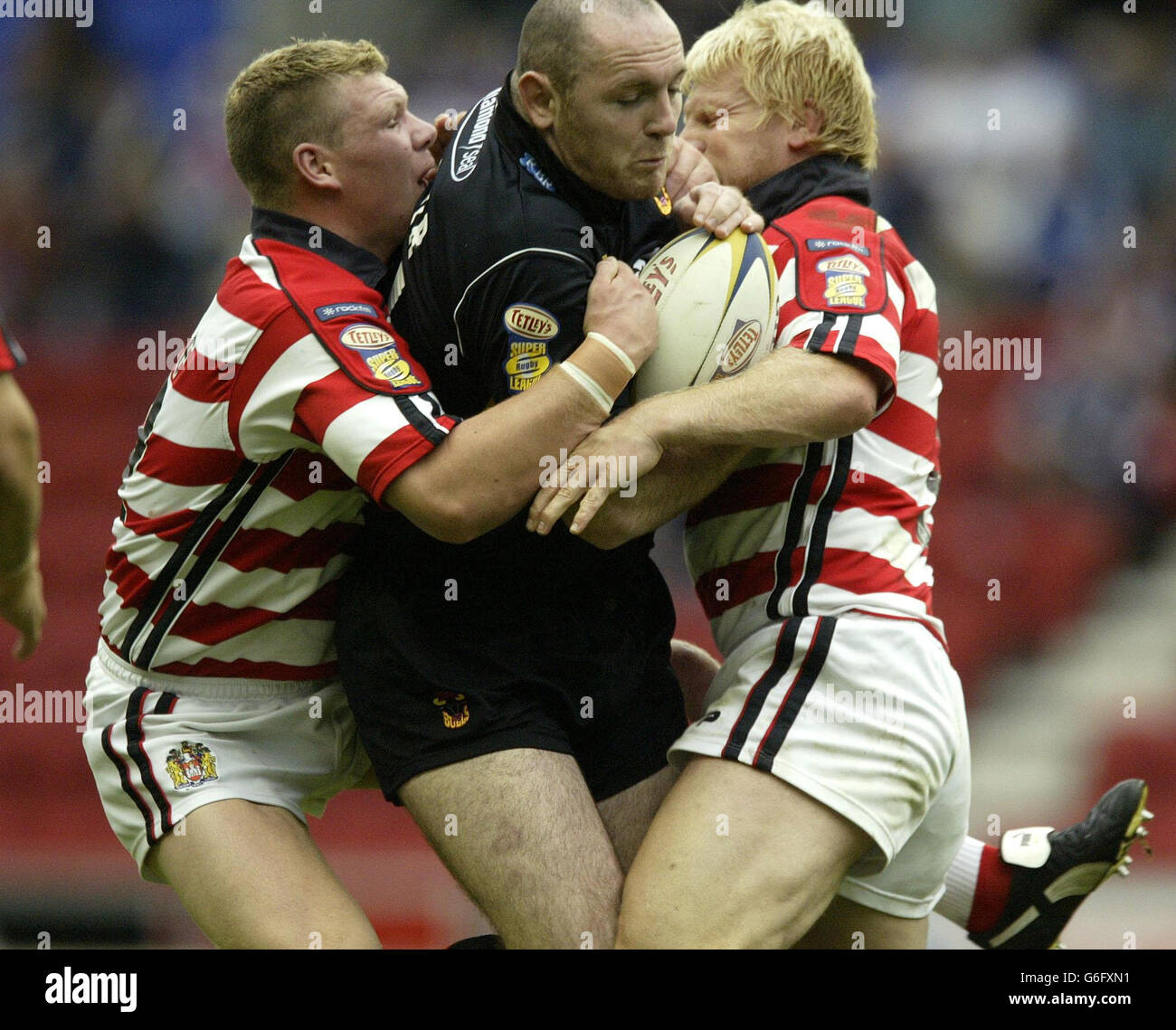 Bradford Bulls' Danny Gartner is held by Wigan Warriors' pair Danny
