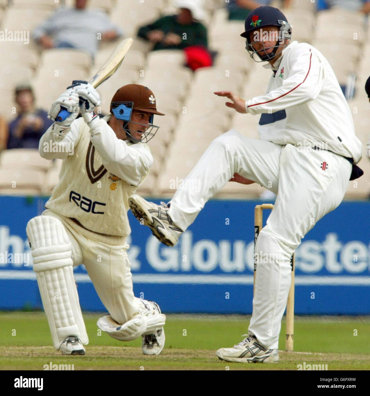 Lancashire fielder Iain Sutcliffe (right) takes evasive action as Surrey batsman Graham Thorpe unleashes a square drive off the bowling of Carl Hooper on the opening day of the Frizzell County Championship match at Old Trafford, Lancashire, Tuesday August 26, 2003. Stock Photo
