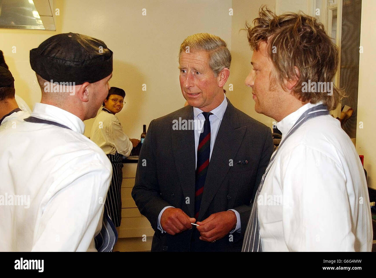 The Prince of Wales with Jamie Oliver (right) and one of his students in the kitchen of Clarence House, his official London residence. Celebrity chef Jamie Oliver is cooking up an organic feast for the Prince of Wales, helped by students from his restaurant Fifteen. The star, who is currently taking a year off TV to devote time to his family and the restaurant venture, will dish up dinner at Charles's official London residence Clarence House. The Prince is hosting the event for VIP guests, farmers and key players in the organic food industry to mark the progress of organic food over the last Stock Photo