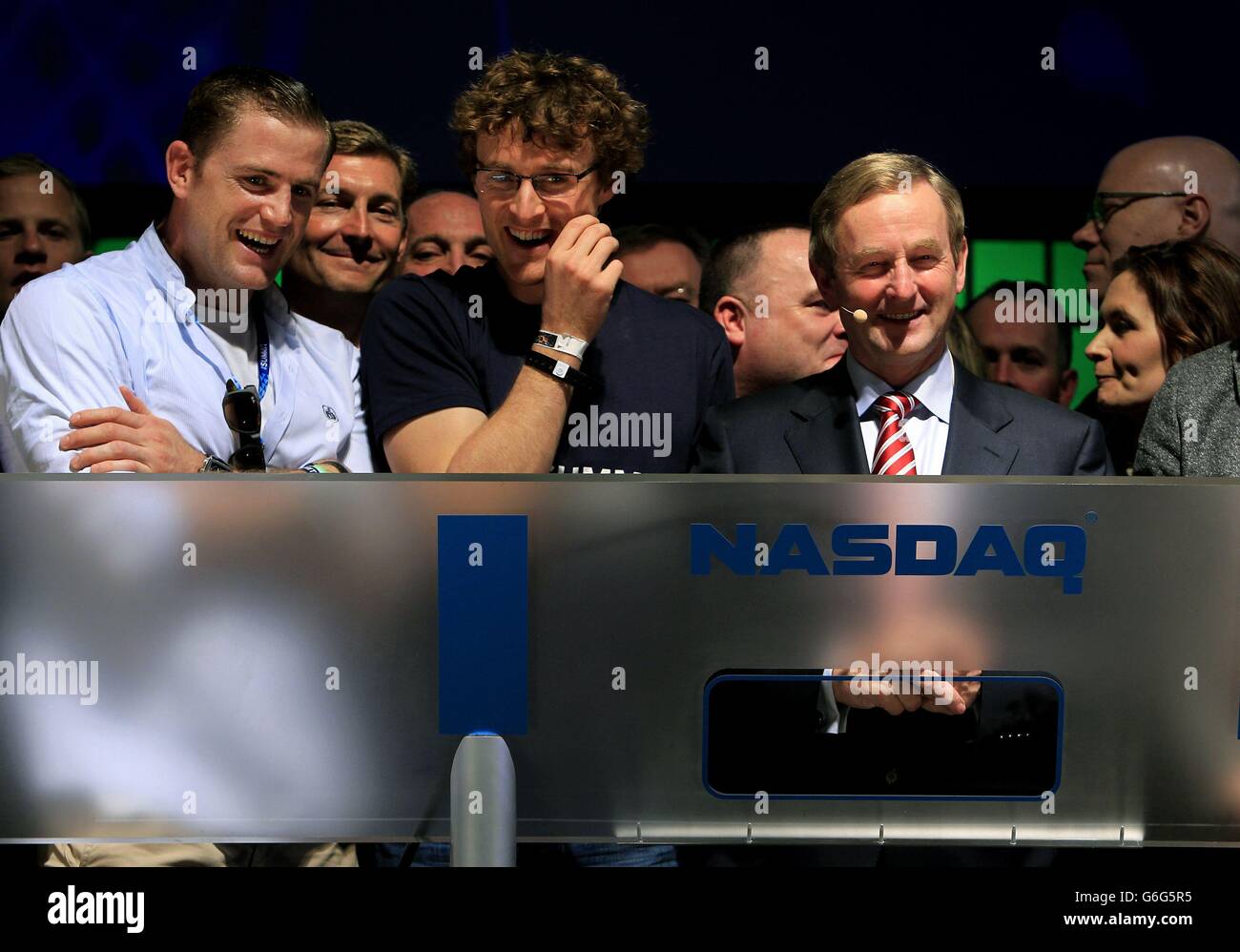 An Taoiseach Enda Kenny TD (right) accompanied by Ireland rugby star Jamie Heaslip (left),and Paddy Cosgrave, founder of the Dublin Web Summit (second left) after ringing the opening bell to for the NASDAQ for the first time ever in Ireland, at the RDS, Dublin, where Websumit 2013 is taking place. Stock Photo