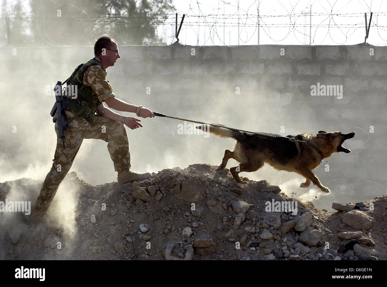 Gunner Simon Stupple with his dog Denzil, whilst out on patrol near the Iraqi port of Umm Qsar. British troops serving in southern Iraq spoke today of their hopes for the country's future as they patrolled one of its first ports to begin thriving since the end of the conflict. Stock Photo