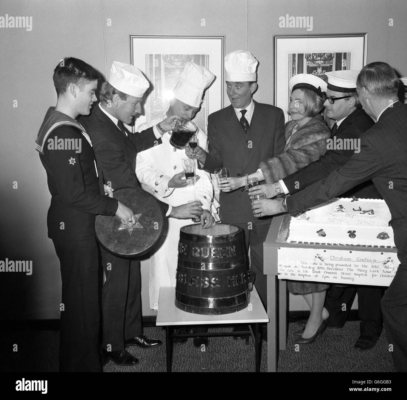 Stars of the BBC's Navy Lark visit the Royal Navy Catering Display at State House, High Holborn, London. They received a large celebration cake to present to the Great Ormond Street Children's Hospital. (l-r) Steward Lionel Parry, Leslie Phillips, CPO Cook Alfred Fielding, Michael Bates, Heather Chasen, Ronnie Barker, and producer Alistair Scott Johnston. Stock Photo