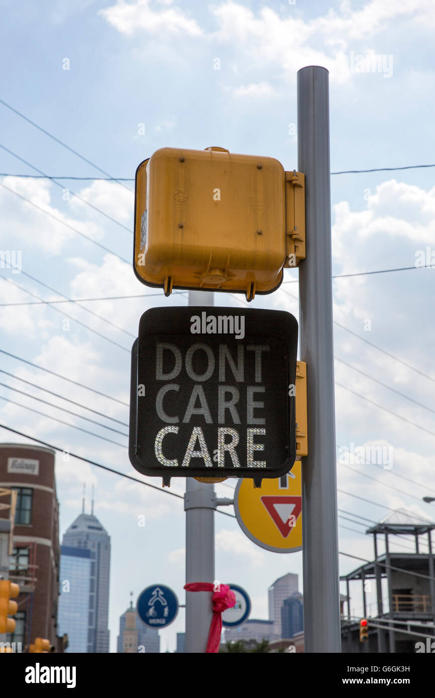 Street crossing sign displaying "Care" rather than "Cross", downtown