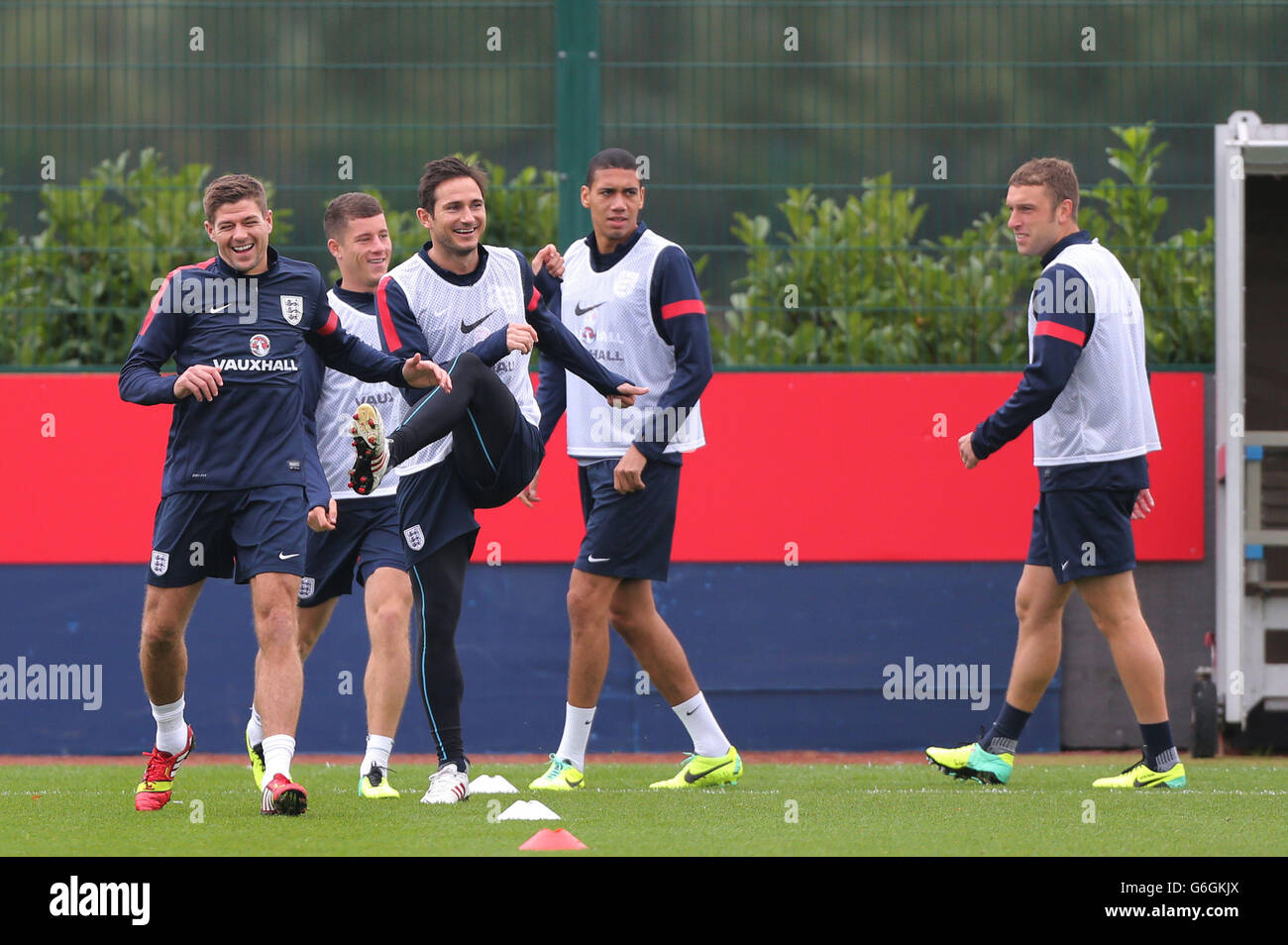 England's Steven Gerrard share a joke as he leads the players in warm up with Frank Lampard, Ross Barkley, Chris Smalling, Ricky Lambert, and (right) during the training session at London Colney, Hertfordshire. Stock Photo