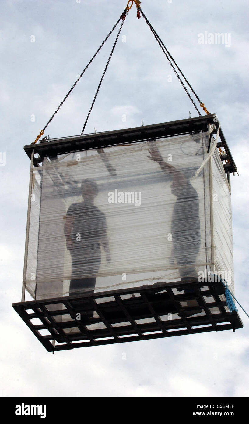 American magician David Blaine (left) and an advisor in a practice run, on the site near Tower Bridge, London, where he is to attempt to spend 44 days suspended in a clear plastic box without food. The American magician is planning to live in a 7ft x 7ft x 3ft box without any distractions or food while dangling over the river Thames. Blaine's only nourishment throughout the six-week challenge will be water. Stock Photo