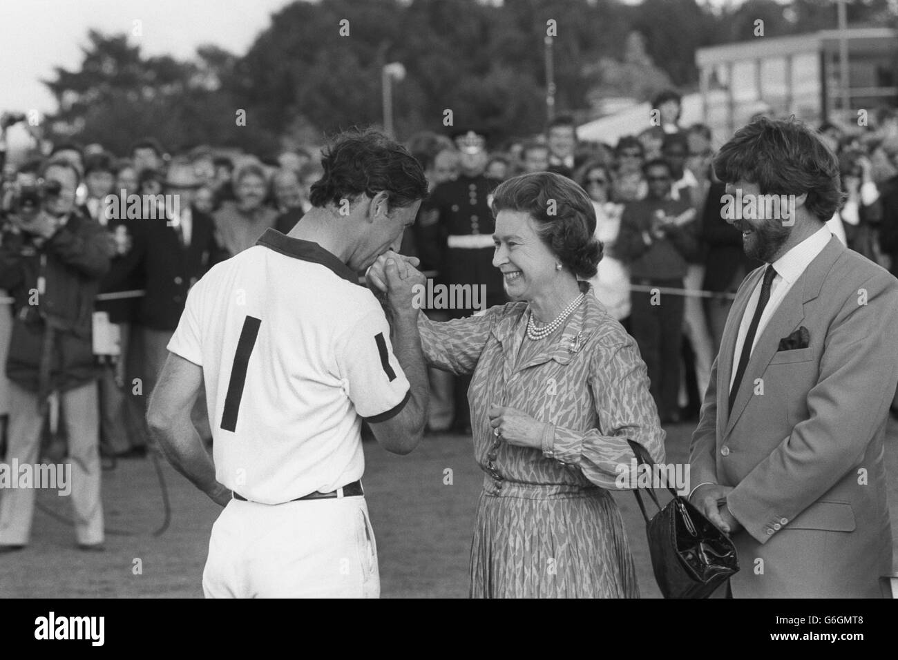 Prince Charles gallantly kisses the hand of his mother, Queen Elizabeth II, at the presentation ceremony of the Silver Jubilee Cup at the Guards Polo Club, Windsor Great Park. The Prince's team, England II, beat Brazil to take the cup. Stock Photo