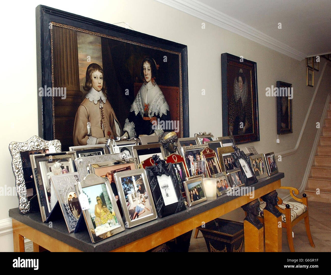 Numerous picture frames for sale (but not the photographs in them) in front of a painting attributed to Edward Bowyer expected to get 20,000 to 30,000, pictured in Sir Elton John's London house. Hundreds of items belonging to the pop star are up for auction at Sotheby's on September 30, 2003. The collection is expected to fetch in excess of 800,000. Stock Photo