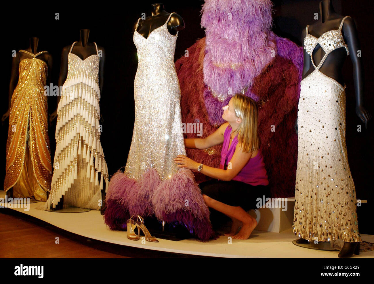 Gowns worn over the 50-year career of singer Dame Shirley Bassey are arranged for a charity auction at Christie's, by Jill Potterton. The proceeds from the sale, which takes place next Thursday, are to go to two Welsh Charities; The Dame Shirley Bassey Scholarship and the Noah's Ark Appeal. From left the gowns, all designed by Douglas Darnell, are as follows; Goldfinger (1960s-70s, worn in the James Bond film whose title song was sung by Dame Shirley), a 'shimmy' dress (1990s), the Diamond Dress (1955-80s) and the White Harem Dress (1960s). Stock Photo