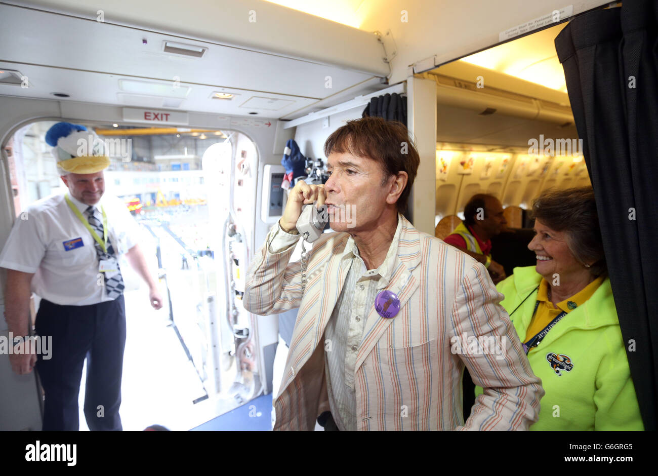 Sir Cliff Richard performs a revised version of his song Summer Holiday over the PA system onboard the British Airways Dreamflight plane before it flies to Florida, USA. Stock Photo