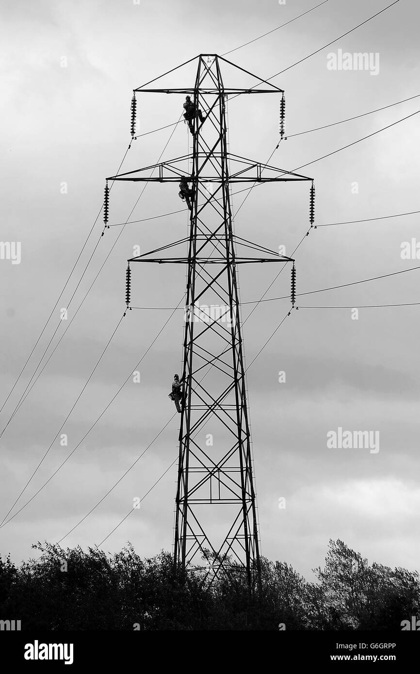 Workmen climb electricity pylon to carry out maintenance in monkspath
