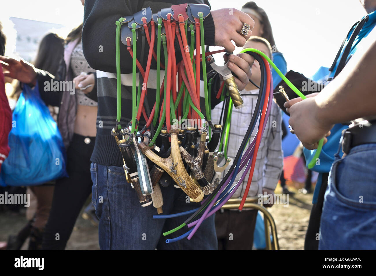 People browse hand-made slingshots and catapults from a wandering trader at the Stow-on-the-Wold Horse Fair in Gloucestershire, where members of the traveling community meet up and trade goods, the event has existed for hundreds of years. Stock Photo