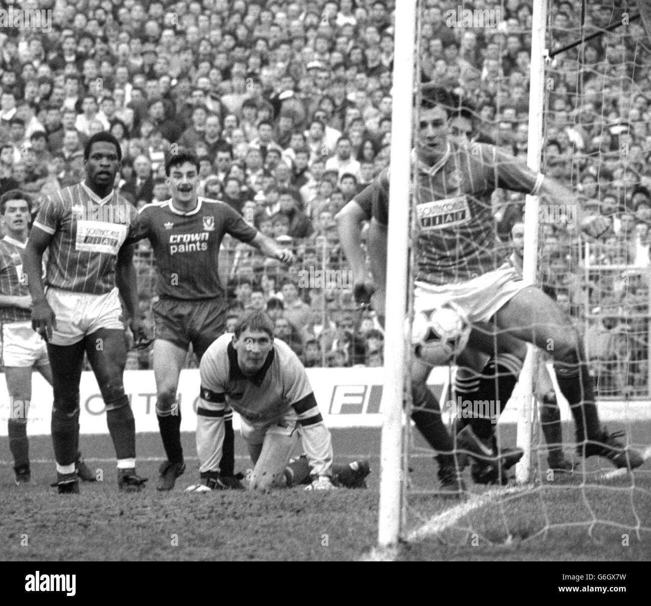 Portsmouth's kneeling goalkeeper Alan Knight and the Portsmouth defence watch in disbelief as John Barnes's cross flies into the goal opening the scoring for Liverpool at Fratton Park. Liverpool's John Aldridge (3rd left) looks on with apparent delight, four minutes into the second half of the Barclays League Division One match. Stock Photo