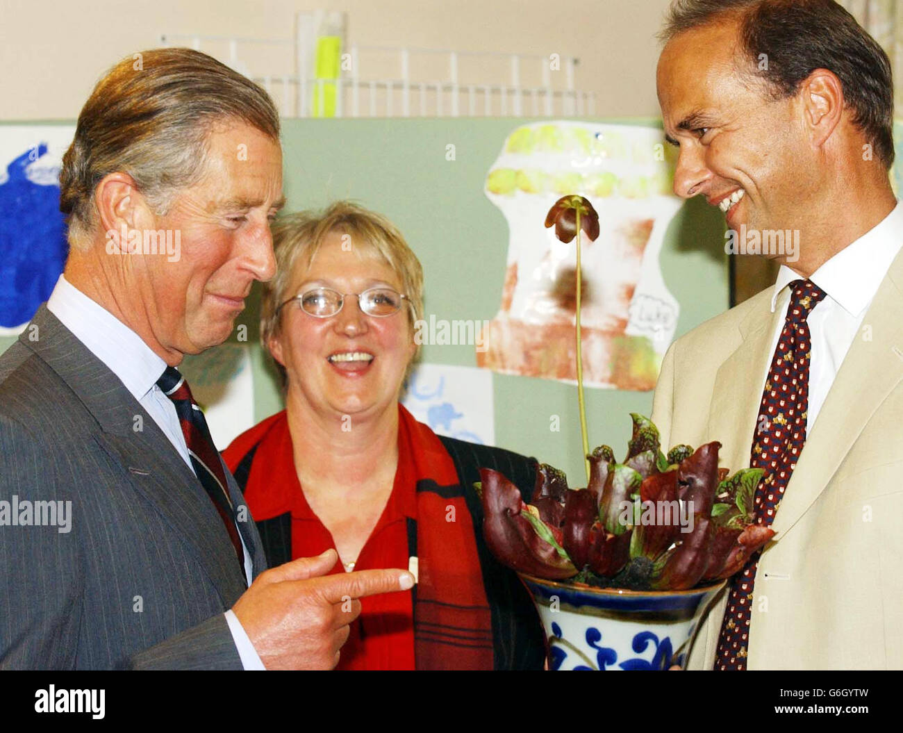 HRH The Prince of Wales (left) is presented with a Pitcher Plant (Sarracenia Purpura Purpura) by Dr David Jenner as Wendy Evans looks on during his visit to College Surgery in Cullompton, Devon, Stock Photo