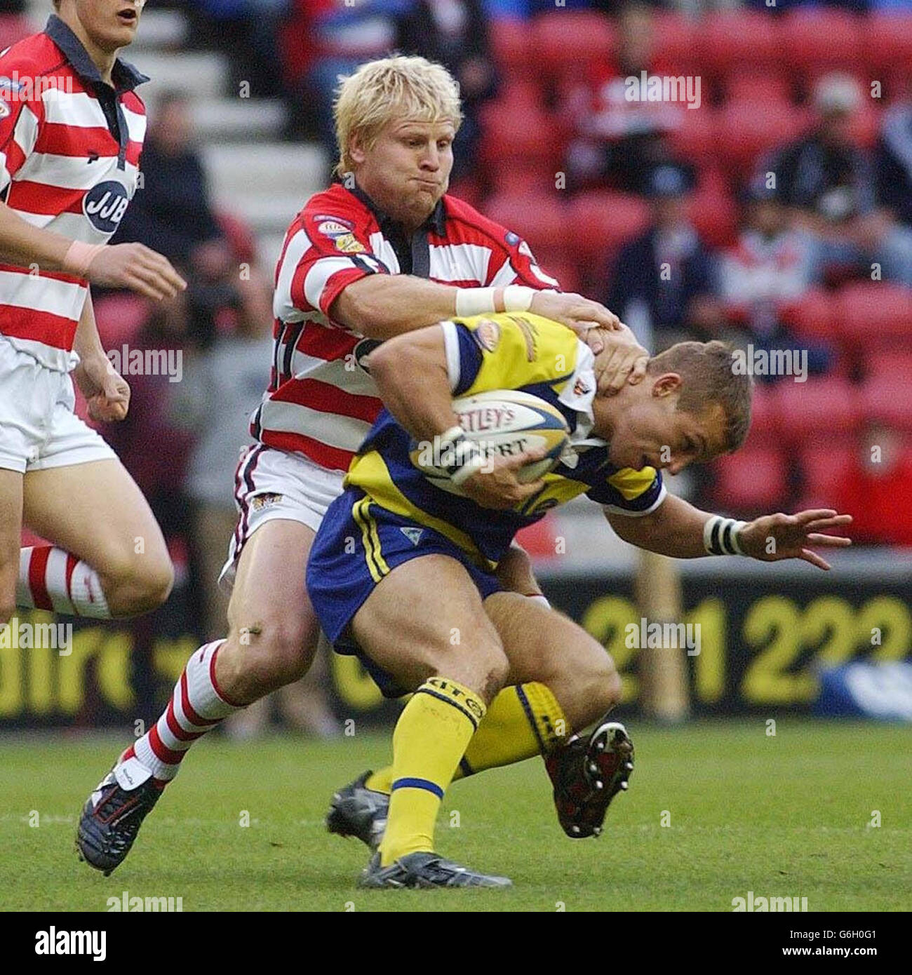 Warrington's Dean Gaskell is tackled by Wigan's Mick Cassidy during the Tetley's Super League play-off at the JJB Stadium, Wigan. Stock Photo