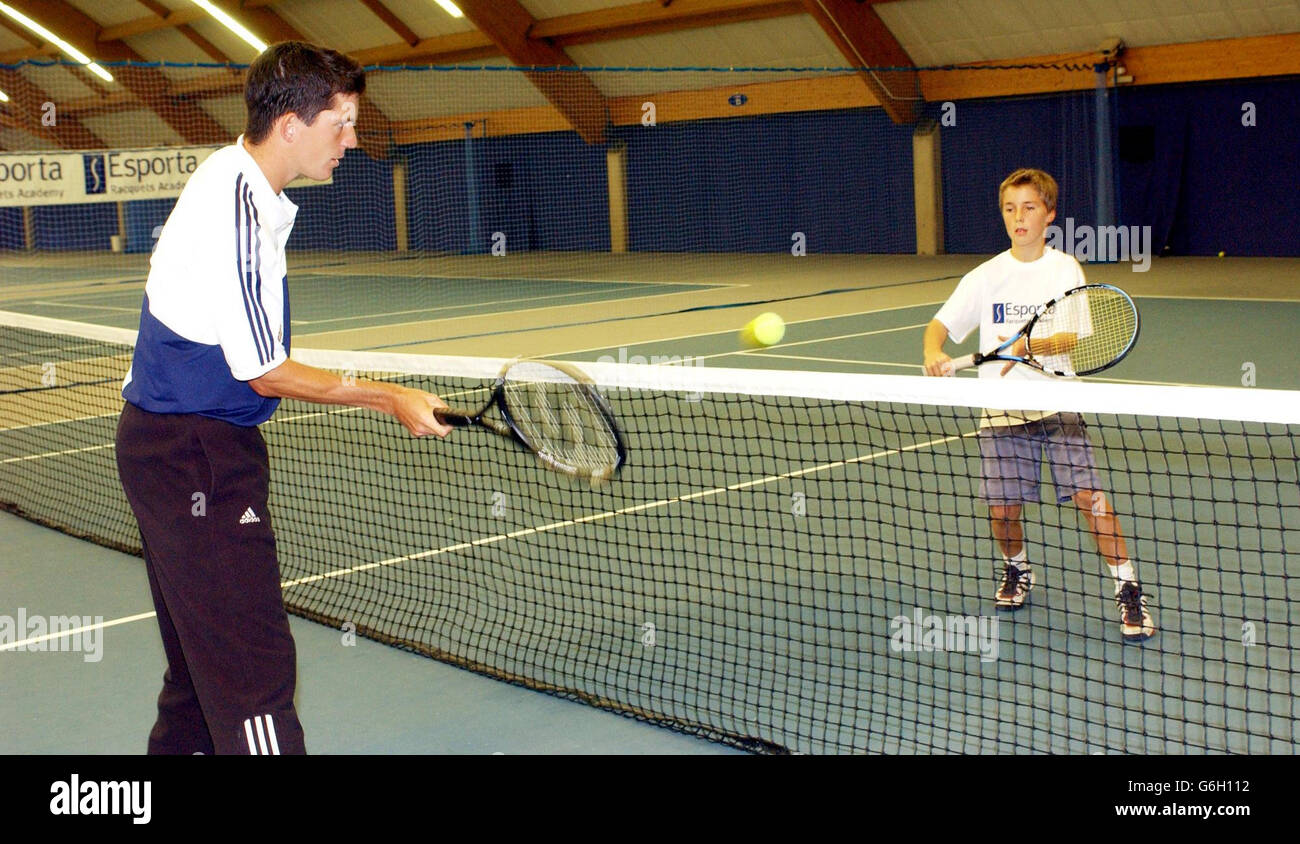 British number one player, Tim Henman (left), plays against Joe Salisbury, 11, joint number one in his age group, during the launch of the Esporta Academy in Chiswick,