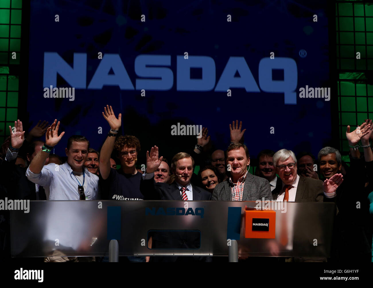 An Taoiseach Enda Kenny TD (centre) accompanied by Ireland rugby star Jamie Heaslip (first left), Paddy Cosgrave, founder of the Dublin Web Summit (third left) and Bruce Aust, Nasdaq's head of listings (third right) after ringing the opening bell to for the NASDAQ for the first time ever in Ireland, at the RDS, Dublin, where Websumit 2013 is taking place. Stock Photo