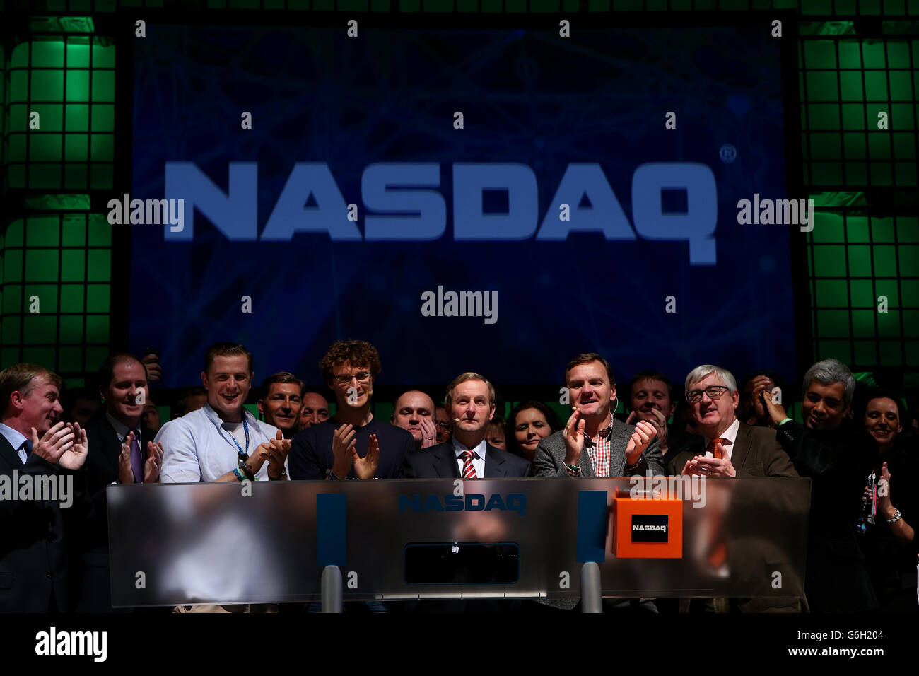 An Taoiseach Enda Kenny TD (centre) accompanied by Ireland rugby star Jamie Heaslip (third left), Paddy Cosgrave, founder of the Dublin Web Summit (sixth left) and Bruce Aust, Nasdaq's head of listings (fifth right) after ringing the opening bell to for the NASDAQ for the first time ever in Ireland, at the RDS, Dublin, where Websumit 2013 is taking place. Stock Photo