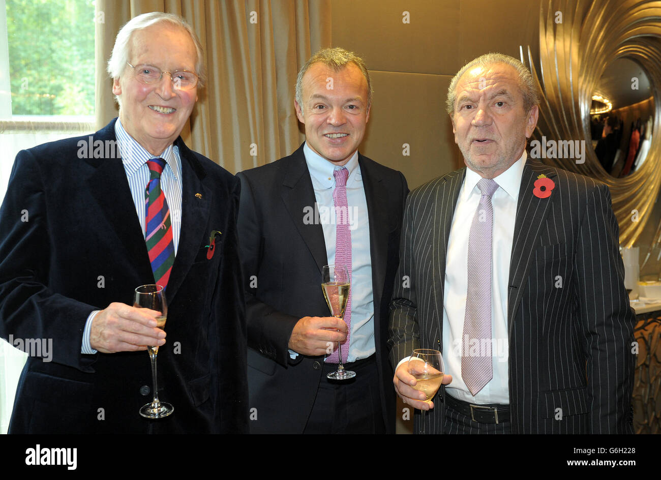 Guest of honour Graham Norton meets Nicholas Parsons (left) and Lord Alan Sugar as he attends a tribute lunch hosted by The Lady Taverners at the Dorchester Hotel, London. Stock Photo