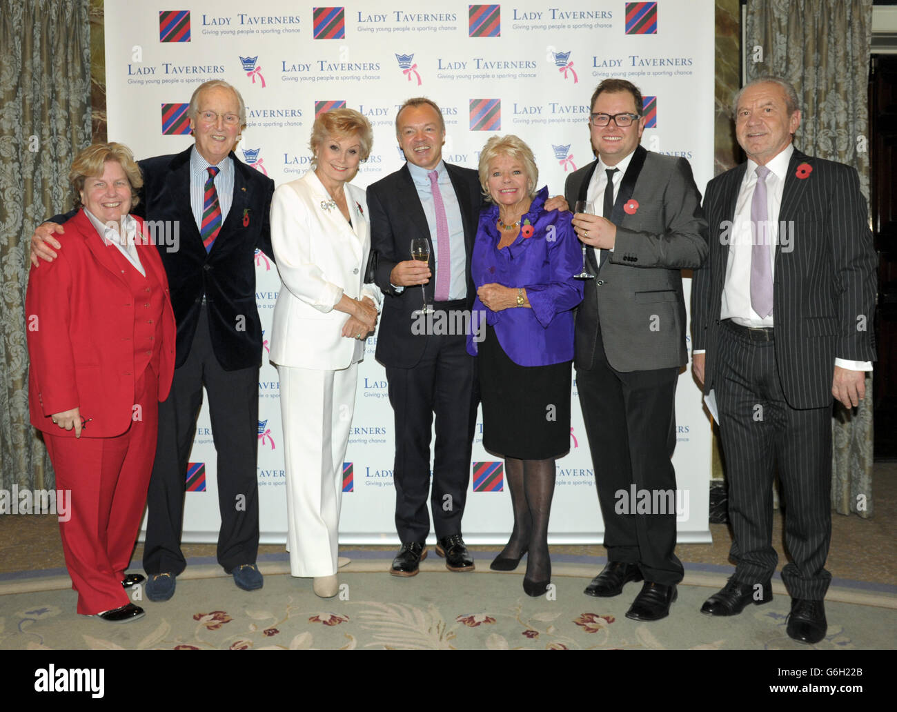 Guest of honour Graham Norton (centre) poses with (left to right) Sandy Toksvig, Nicholas Parsons, Angela Rippon, President Emeritus Judith Chalmers, Alan Carr and Sir Alan Sugar during a tribute lunch hosted by The Lady Taverners at the Dorchester Hotel, London. Stock Photo