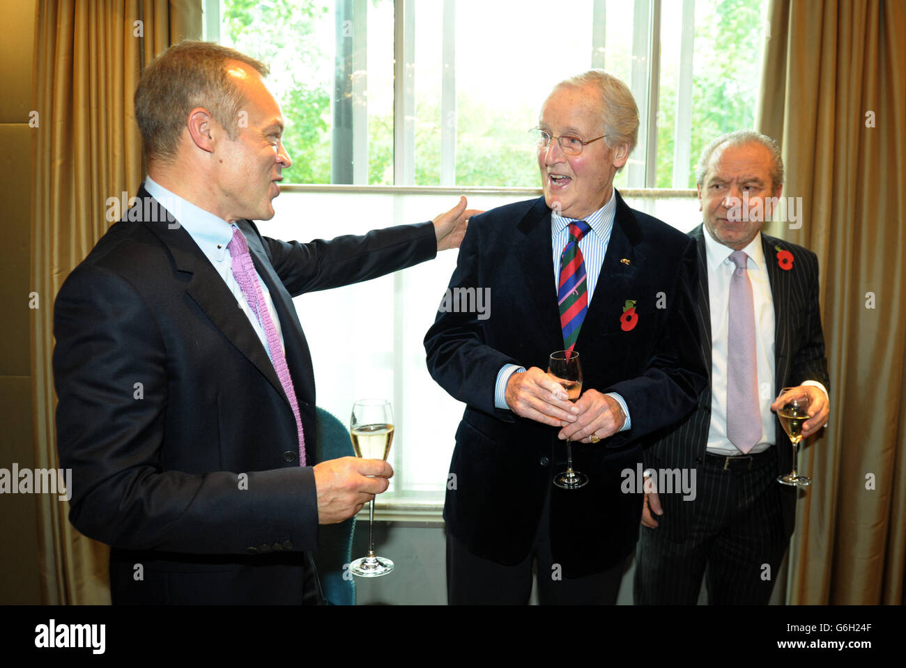 Guest of honour Graham Norton meets Nicholas Parsons (centre) and Lord Alan Sugar as he attends a tribute lunch hosted by The Lady Taverners at the Dorchester Hotel, London. Stock Photo