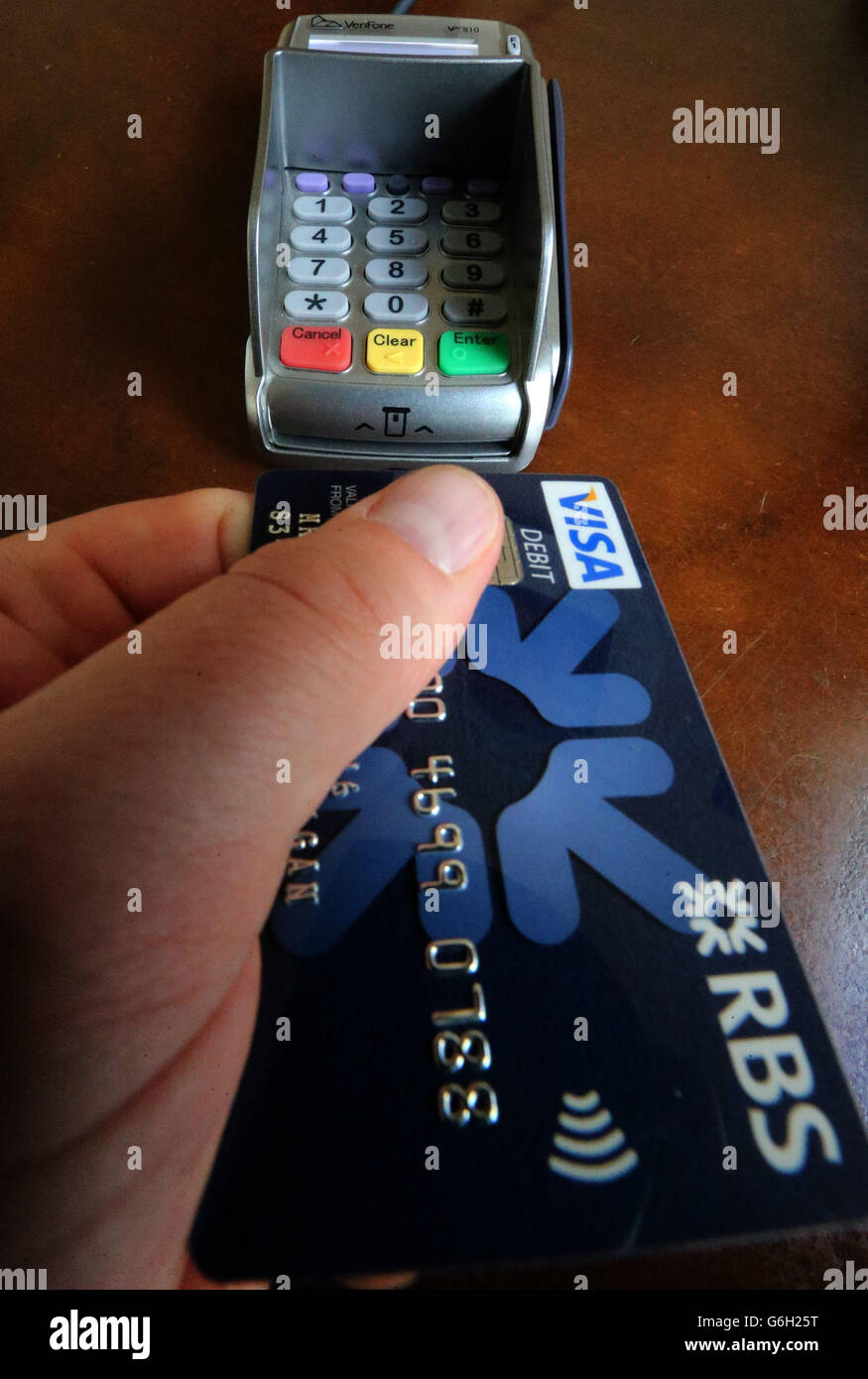 A person uses a Royal Bank of Scotland card in a portable payment terminal at a shop in Stirling. The RBS dodged a full break-up today as it revealed plans for the rapid wind-down of £38 billion of toxic loans while slashing costs. Stock Photo
