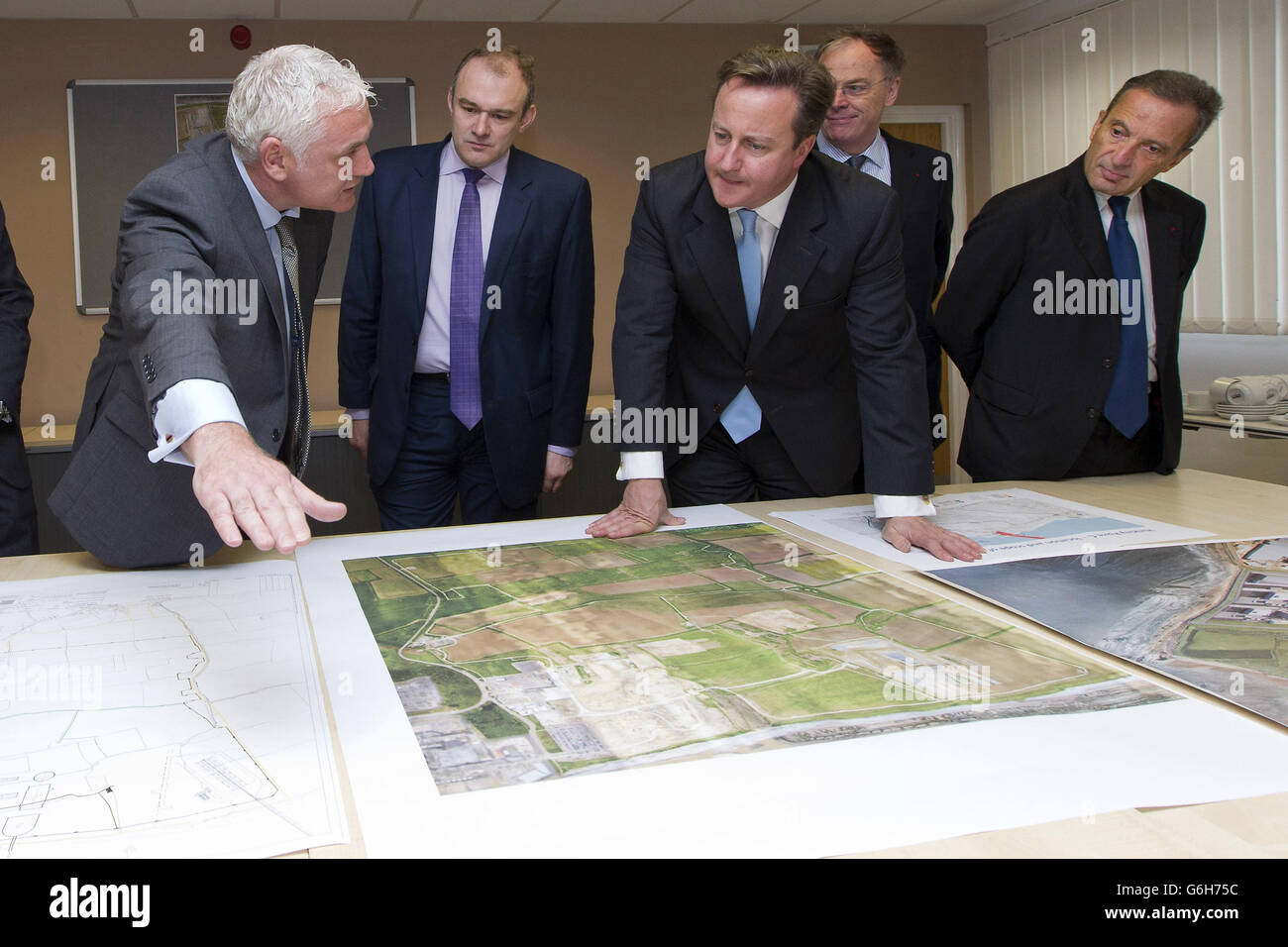 (left to right) Nigel Cann site director of Hinkley Point C, Energy Secretary Ed Davey, Prime Minister David Cameron, Vincent de Rivaz, Chief Executive of EDF (Electricite de France) and Henri Proglio, CEO and Chairman of EDF as they examine site plans for the news Hinkly C nuclear power station at Hinkley Point, Somerset. Britain's first new nuclear power station in a generation is to be built under the &Acirc;&pound;16 billion project which will create thousands of new jobs. Stock Photo