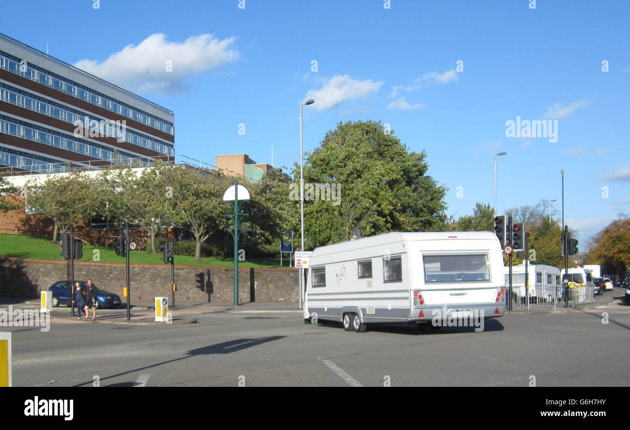 EDITORS NOTE NUMBER PLATE PIXELATED BY PA PICTURE DESK. A car towing a caravan leaves the Royal Gwent Hospital in Newport, south Wales as a group of French travellers left the hospital car park they were using as a make-shift encampment. Stock Photo