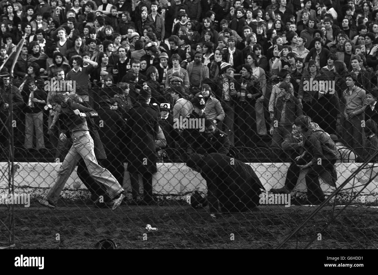 Police in Action at Chelsea. A policeman escorts a fan at Stamford Bridge, where rioting spectators spilled over the barriers before the start of Chelsea's league Division Two promotion battle against London rivals Millwall. Stock Photo