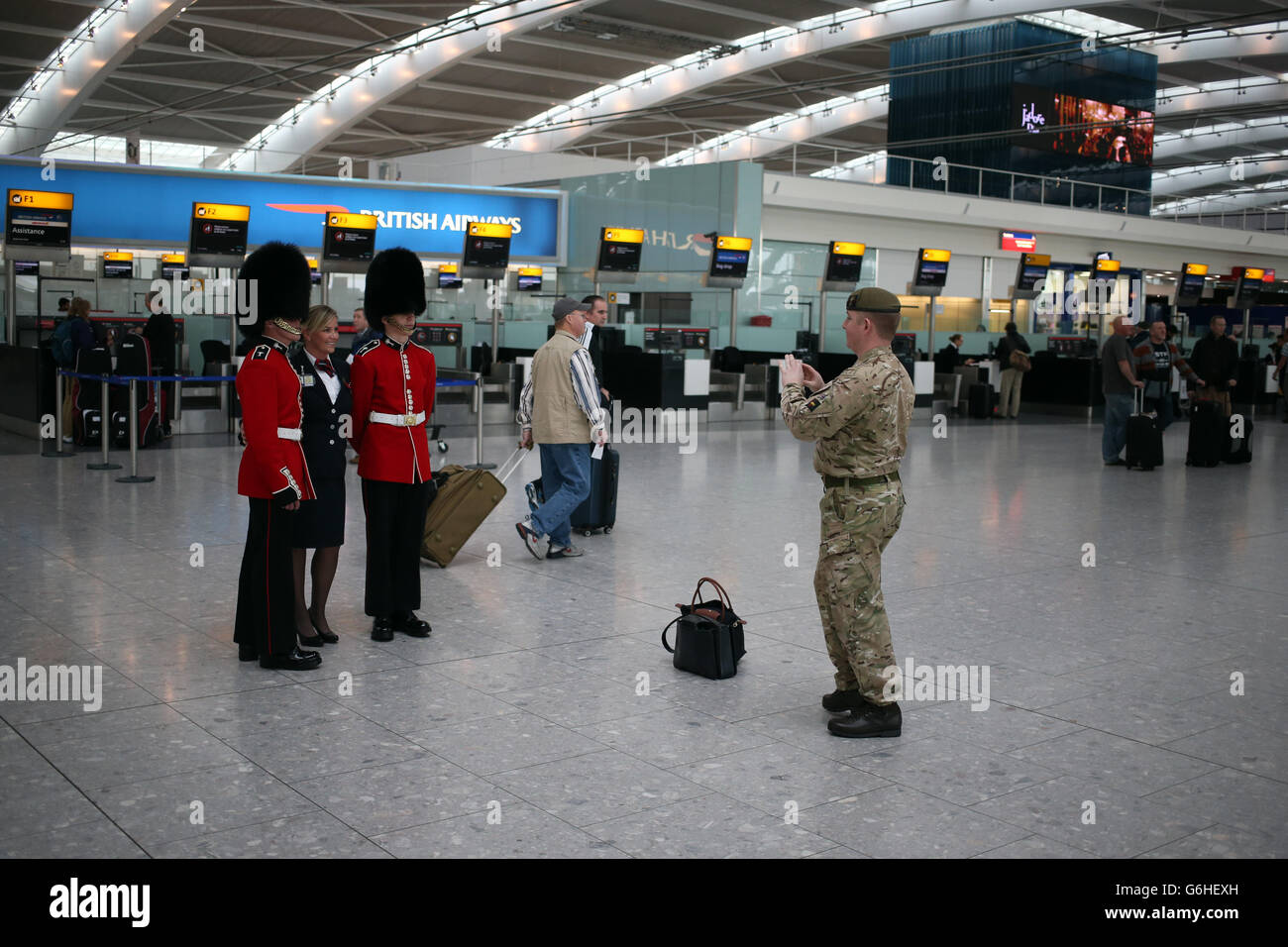 A BA employee with soldiers in terminal 5 at Heathrow airport in London who were joining poppy sellers on Royal British Legion's (RBL) London Poppy Day. Stock Photo