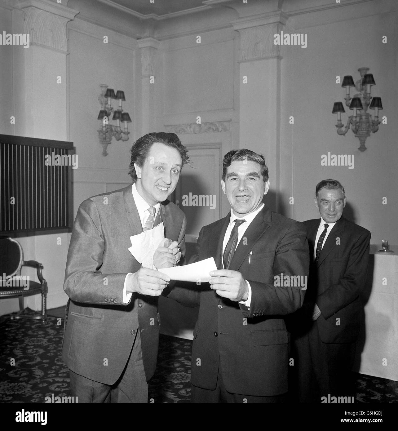 66,229.4s., to Mr Arthur Ramsdale, 40, an underground mechanic of Bilsthorpe colliery, Nottinghamshire, which he won in the Littlewoods Penny Treble Chance, this week. Ken Dodd handed over the cheque to Arthur in a ceremony at Grosvenor House, London. Stock Photo