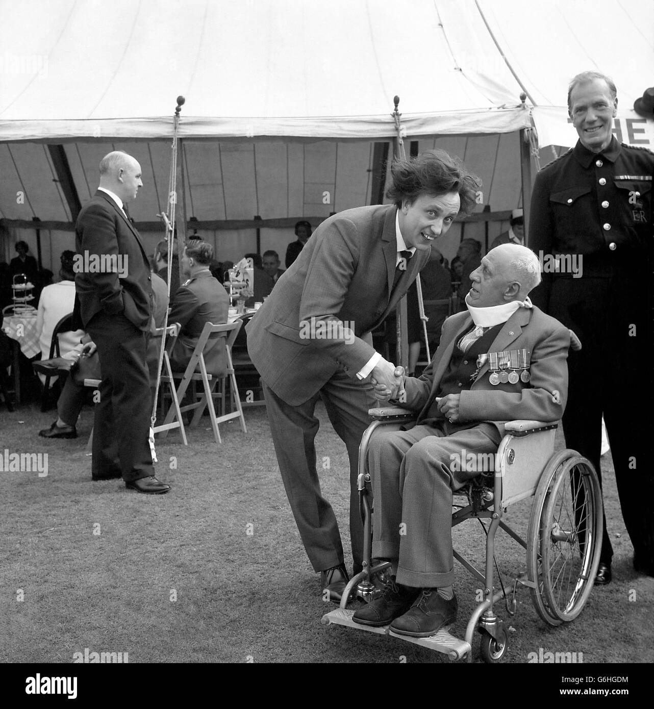 Liverpool comedian Ken Dood chats with fellow Lancastrian variety veteran Mr Harry Leslie, aged 76, at the 'Not Forgotten' Association's garden party in the grounds of Buckingham Palace. Harry, now an inmate of the Variety Artists Home at Twickenham, Middlesex, is a native of Everton. He first appeared on the stage at the age of 10 and performed continuously until forced to give up from a disablement reveived in the World War. Ken Dodd, now appearing at the London Palladium, was one of thecompany who entertained guests at the party. Stock Photo