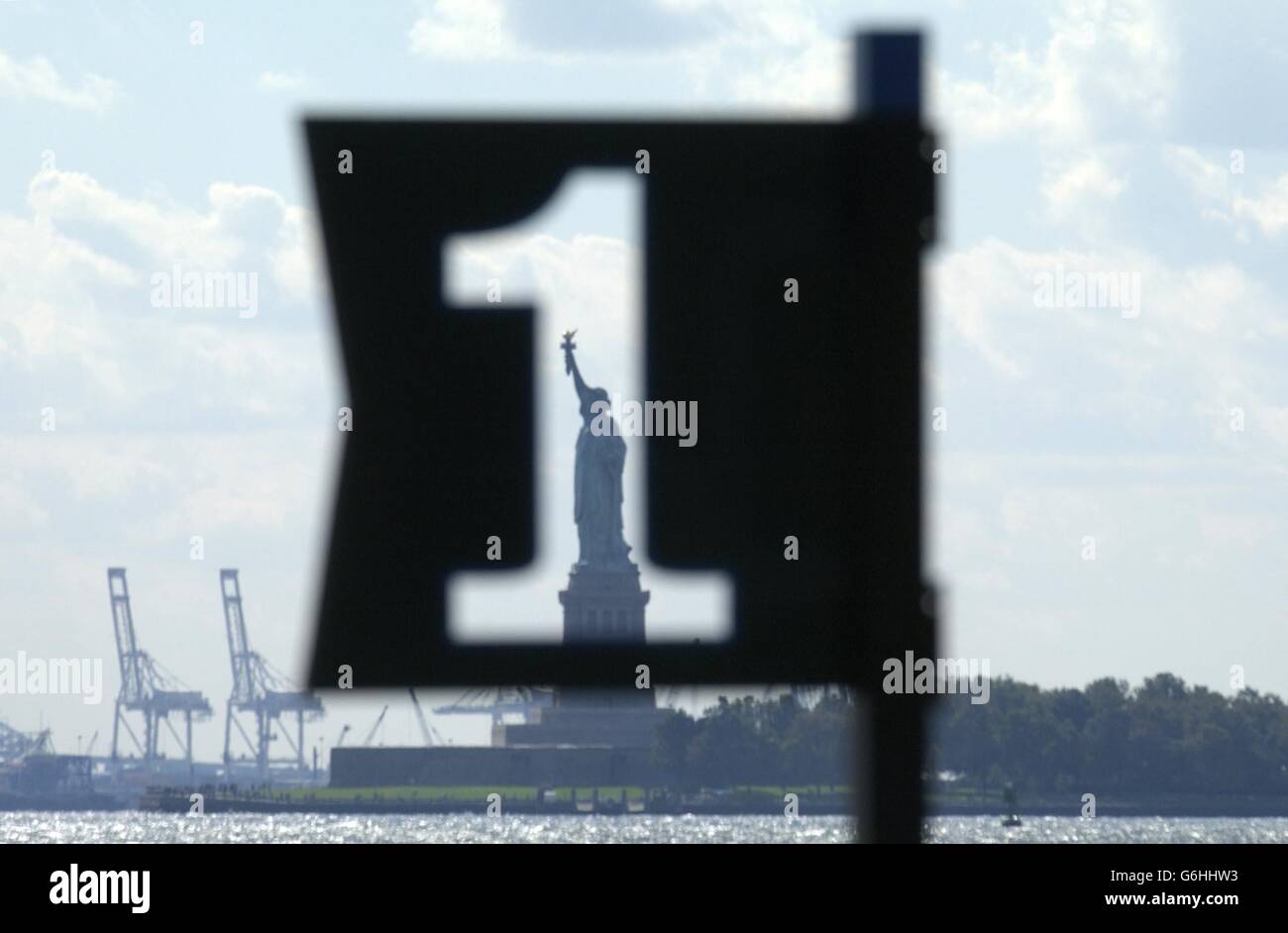 The Statue of Liberty as seen through a Pier marker at the New York docks. The Statue was the first thing that millions of immigrants saw as they sailed into the harbour in the 19th and early 20th centuries, before landing at the notorious Ellis Island to be processed and allowed into the country. Stock Photo