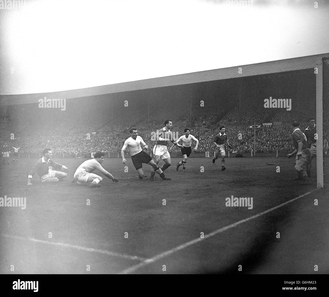 Chelsea's Roy Bentley (3rd from left) scores the third goal for his hat-trick to give England victory in the British Championships international match against Wales at Wembley Stadium, London. (From l-r) Ray Daniel, Wales and Sunderland centre-half, John King, Wales and Swansea goalkeeper, Roy Bentley, England inside right, Roy Paul, Wales and Manchester City right half, Len Shakleton, England and Sunderland inside left, and Derek Tapscott, Wales and Arsenal outside right. On the goal line are Welsh backs Alf Sherwood (Cardiff) and Stuart Williams (West Bromwich Albion). Stock Photo