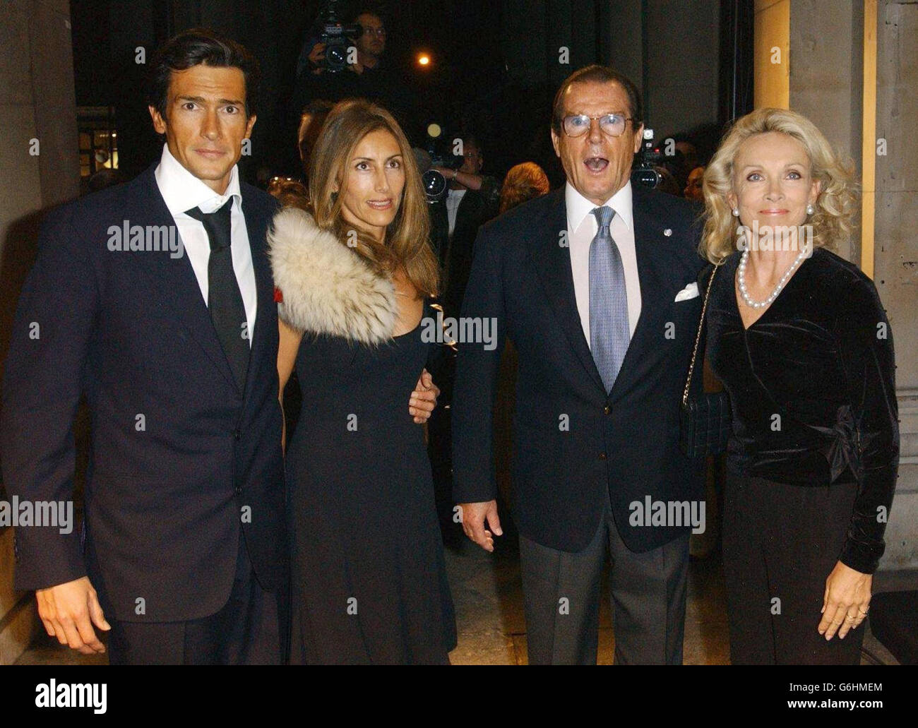 (From left to right) Geoffrey Moore and wife Loulou, Sir Roger Moore and wife Kiki Tholstrup arrive for a cocktail party launch of the Giorgio Armani: A Retrospective exhibition at the Royal Academy of Arts in central London. Stock Photo