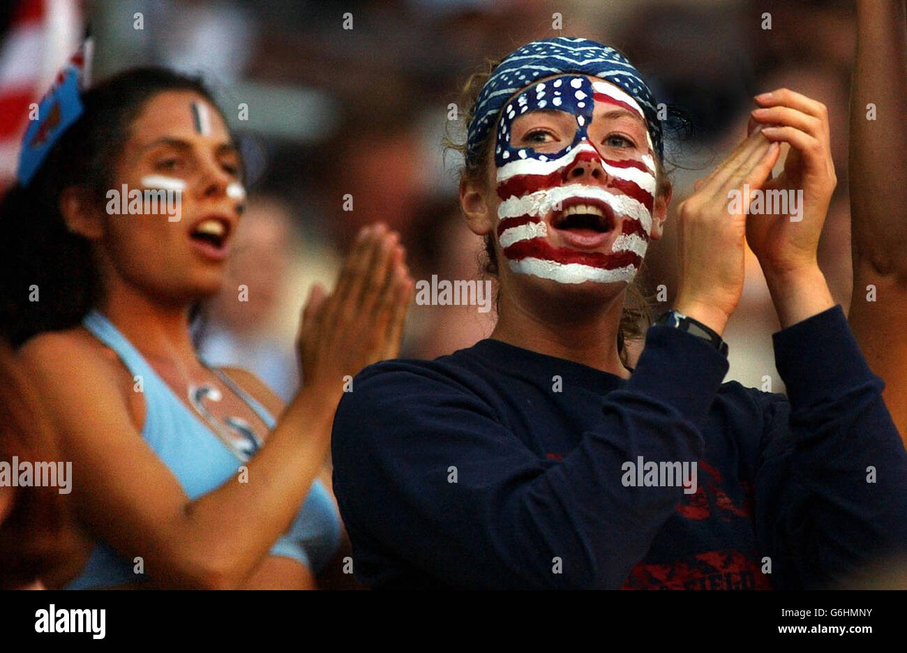 A USA fan stands in front of a Fiji fan, during their Rugby World Cup game in the Suncorp Stadium, Brisbane, Australia. NO MOBILE PHONE USE. INTERNET SITES MAY ONLY USE ONE IMAGE EVERY FIVE MINUTES DURING THE MATCH Stock Photo