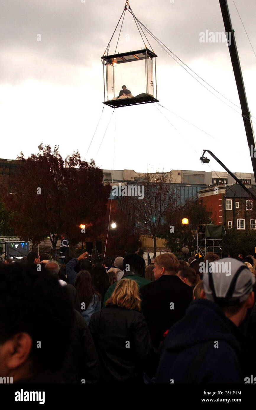 American illusionist David Blaine sits in his perspex box as hundreds of fans gather, at the South Bank near to Tower Bridge, London. Blaine will leave his self-imposed plastic prison later this evening, after 44 days suspended by a crane, with just water to sustain him during this time. Stock Photo