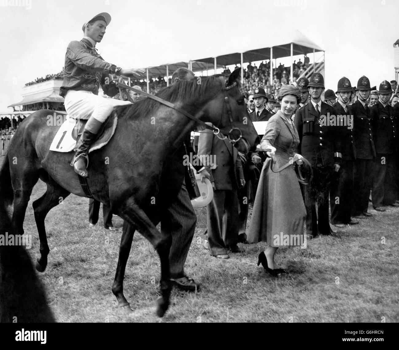 The Queen leads in her Oaks winner, Carrozza, with Lester Piggott in the saddle. The horse was restive as the Queen led her in but quietened down as her Majesty brought her into the winner's circle. Stock Photo