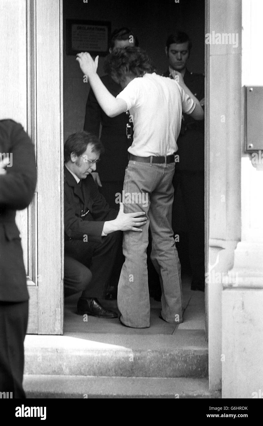 Police frisk a visitor to Bow Street Magistrates' Court, where 10 people accused of plotting the London car bomb explosions were appearing. Stock Photo