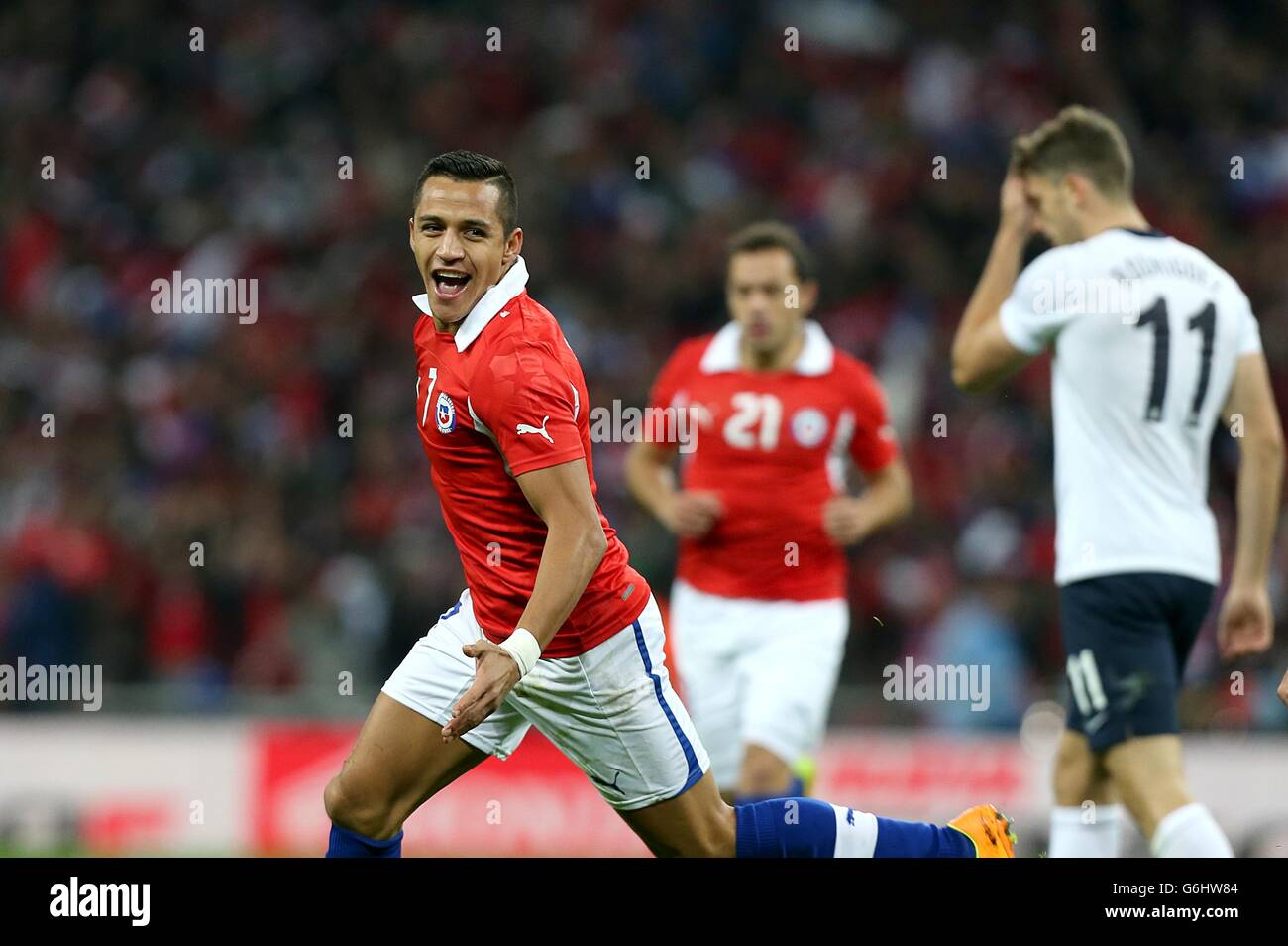 Chile's Sanchez Alexis celebrates scoring their first goal of the game as England's Jay Rodriguez (right) stands dejected Stock Photo