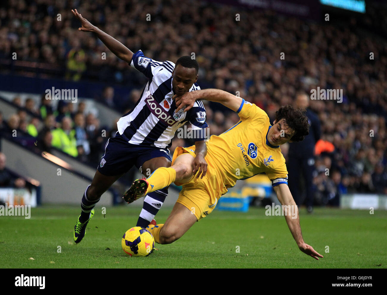 West Bromwich Albion's Saido Berahino rides the tackle from Crystal Palace's Mike Jedinak (right) during the Barclays Premier League match at the Hawthorns, West Bromwich. Stock Photo