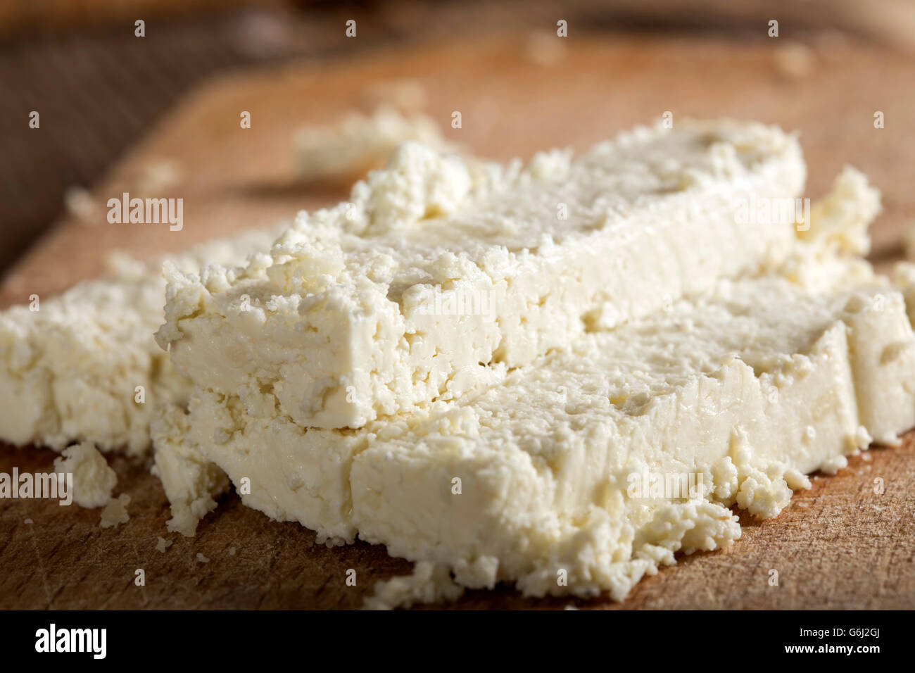 Fresh cheese slices on a wooden background Stock Photo