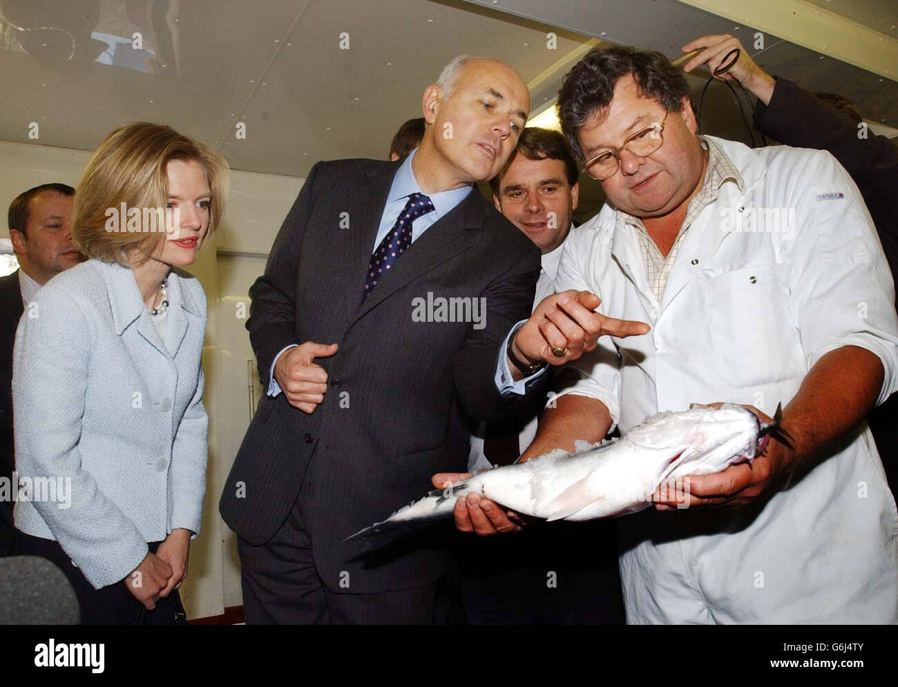 Conservative Party Leader Iain Duncan Smith (centre) and his wife Betsy, talk to Nick Bozman during a visit to the fish market in Looe, Cornwall. The Conservative Leader was in the south west, where he was visiting fishermen in Looe and later touring the Eden Project in St Austell amid continuing controversy over his employment of wife Betsy as an aide, and suspected leadership plotting. Stock Photo